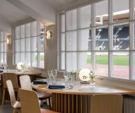 Bistro Stadionin ravintolasta kuva, jossa on pöydästä näkymä nurmelle. Kuva: Wellu Hämäläinen